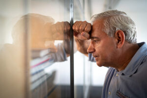 Man with hand and head against the glass